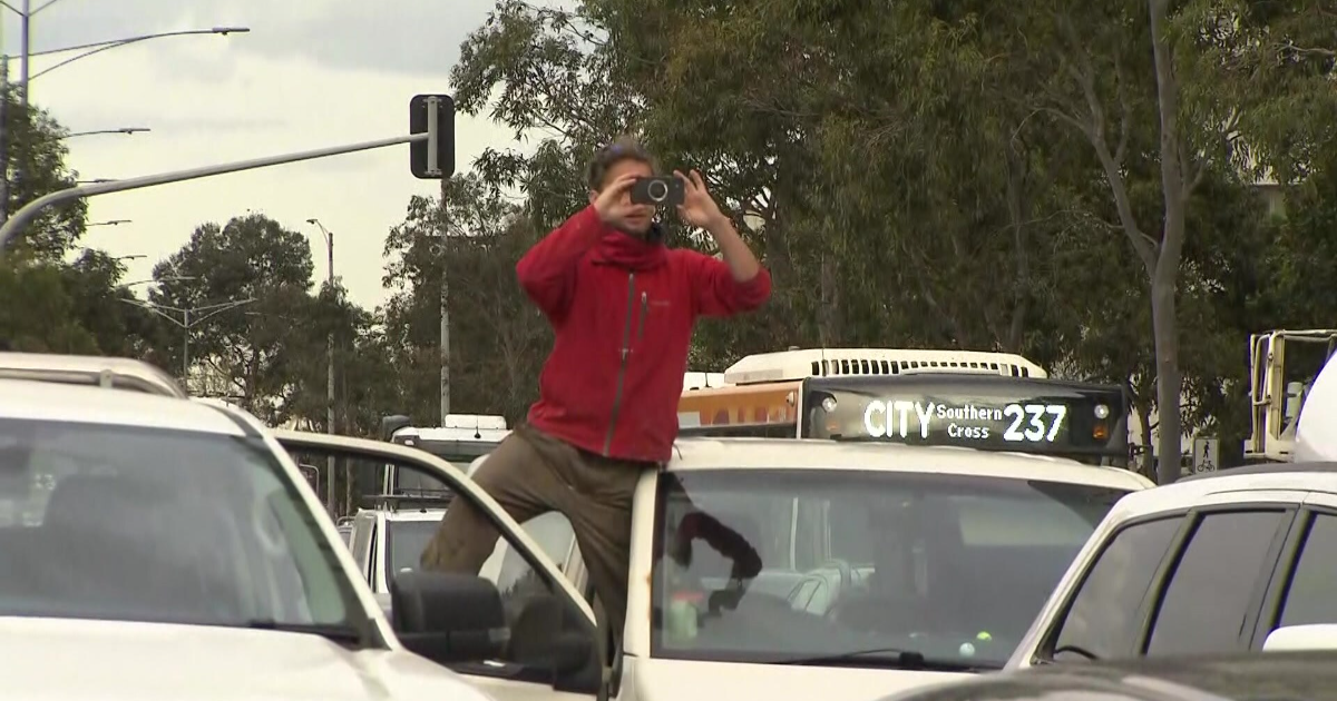 A man taking a photo on a crowded street