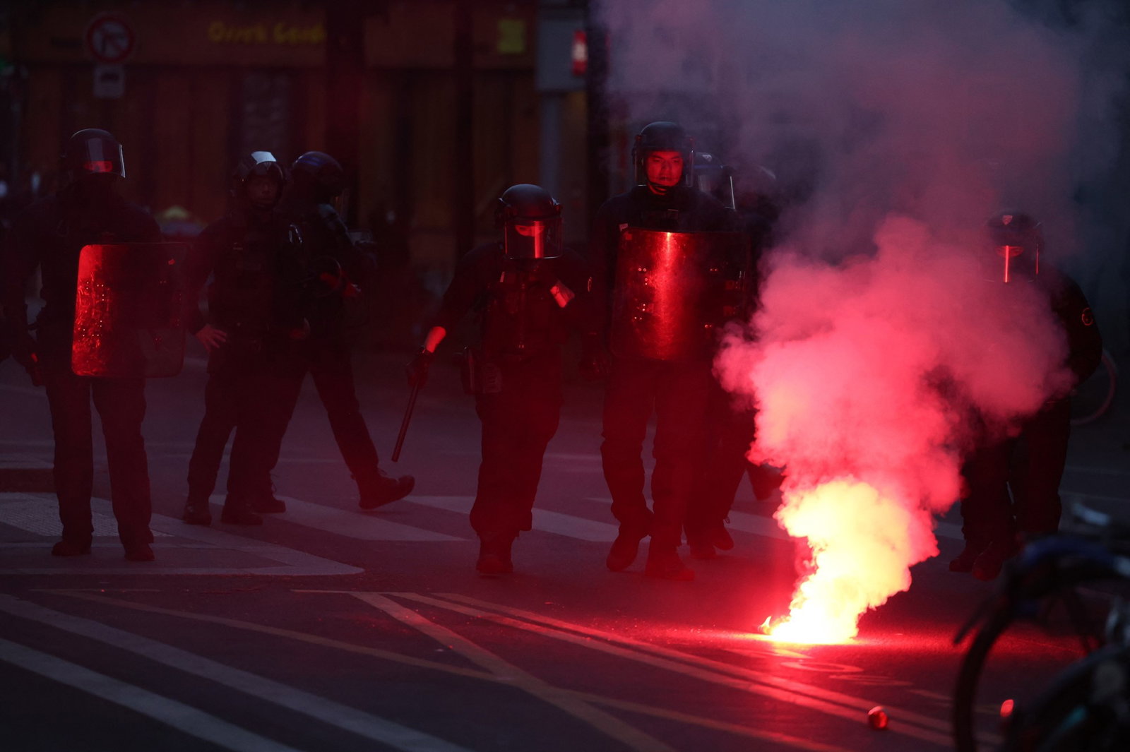 Police stand behind a flare 