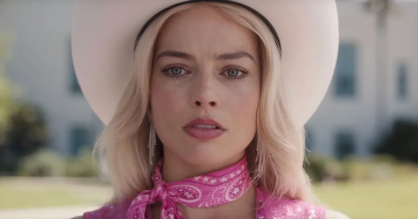 Margot Robbie in character as Barbie, crying.