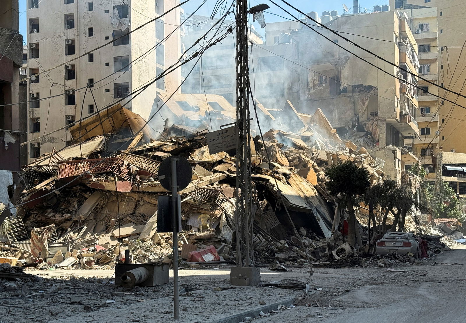 A pile of rubble behind a telephone pole