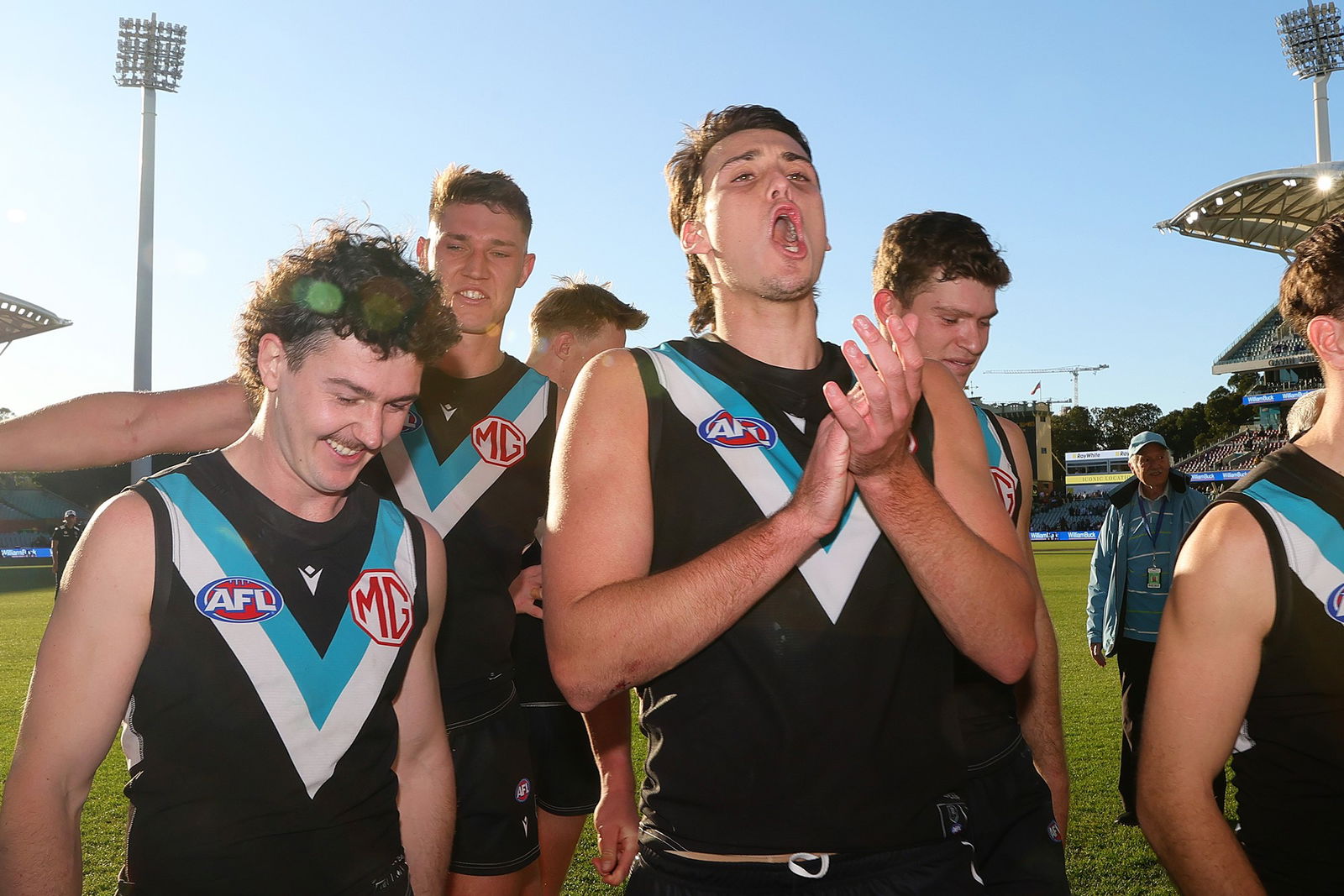 Ollie Lord and Port Adelaide teammates walk off the ground after the win over the Bulldogs