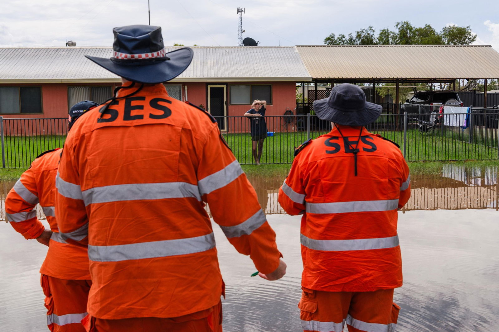 Three SES workers stand in floodwaters.
