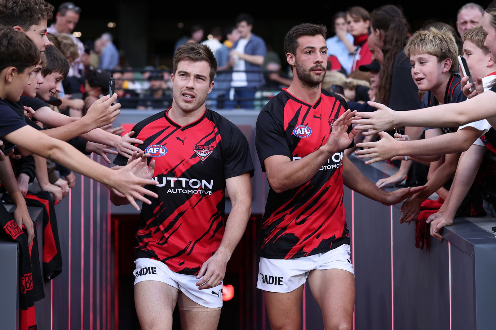 Bombers players run onto the MCG.