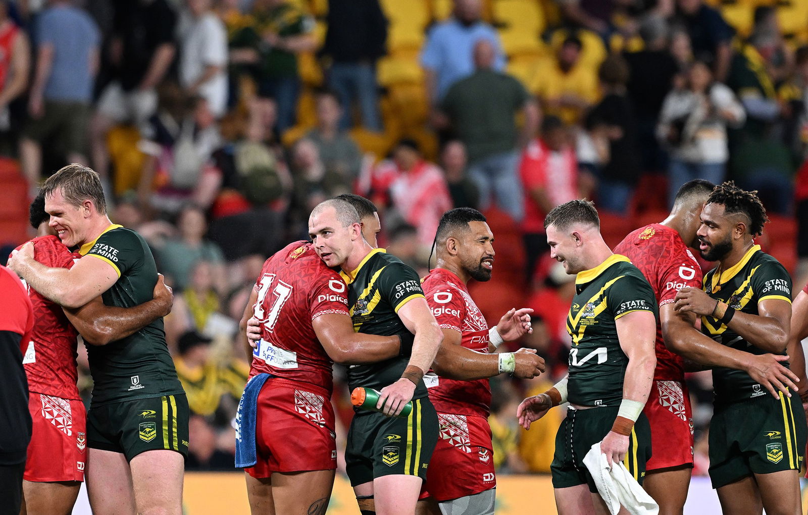 Australian and Tongan rugby league players hug after a Test.