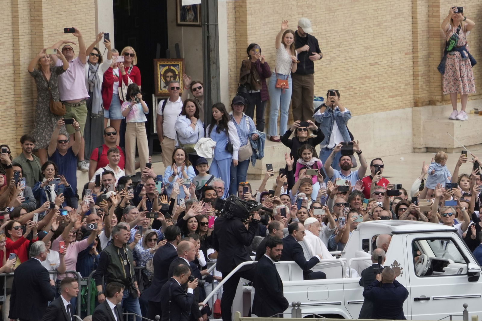 worshippers crowd steps as the popemobile goes past
