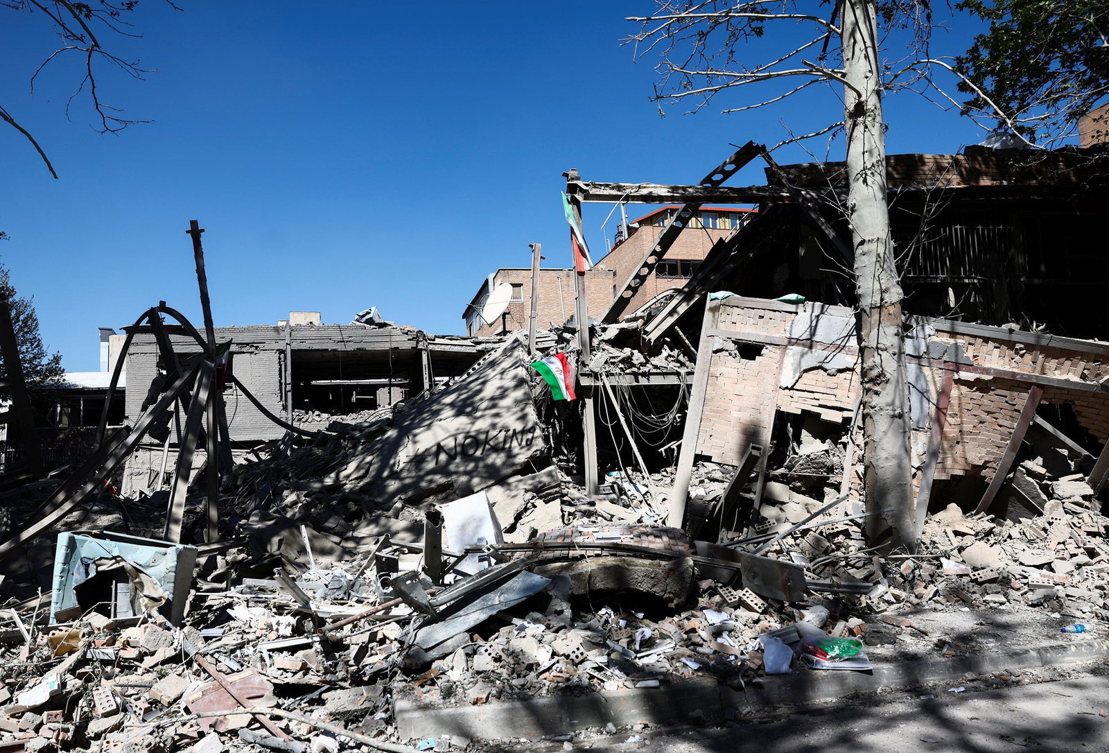 A pile of rubble with an Iranian flag.