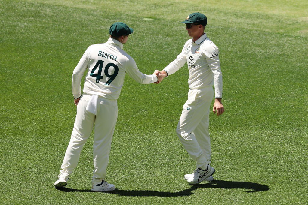 Steve Smith shakes Nathan McSweeney's hand in the field.