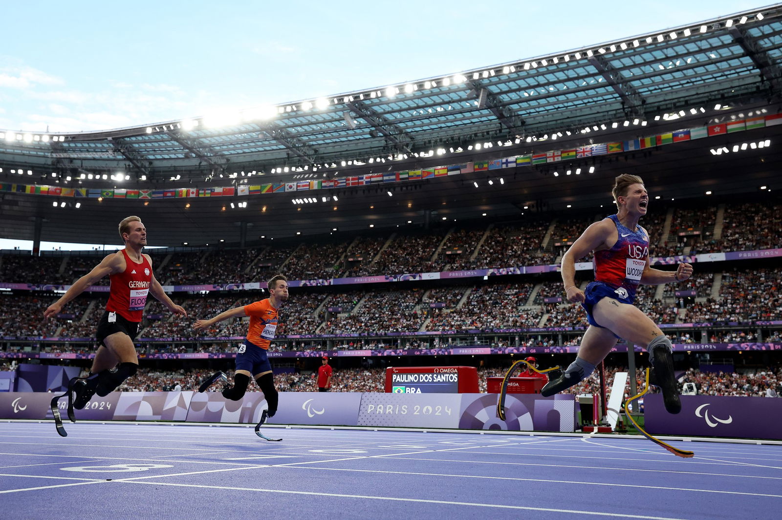 Hunter Woodhall of the US (R) wins ahead of Johannes Floors of Germany (L) and Dutch runner Olivier Hendriks (C) in the final of the men's 400m T62 in Paris.