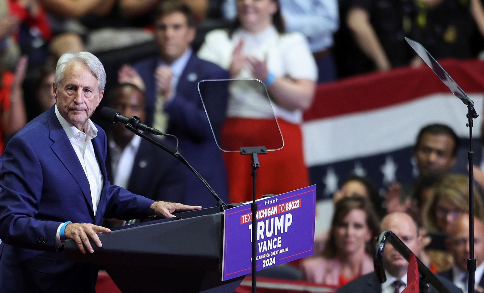 Sandy Pensler grasps the podium on stage at Trump rally