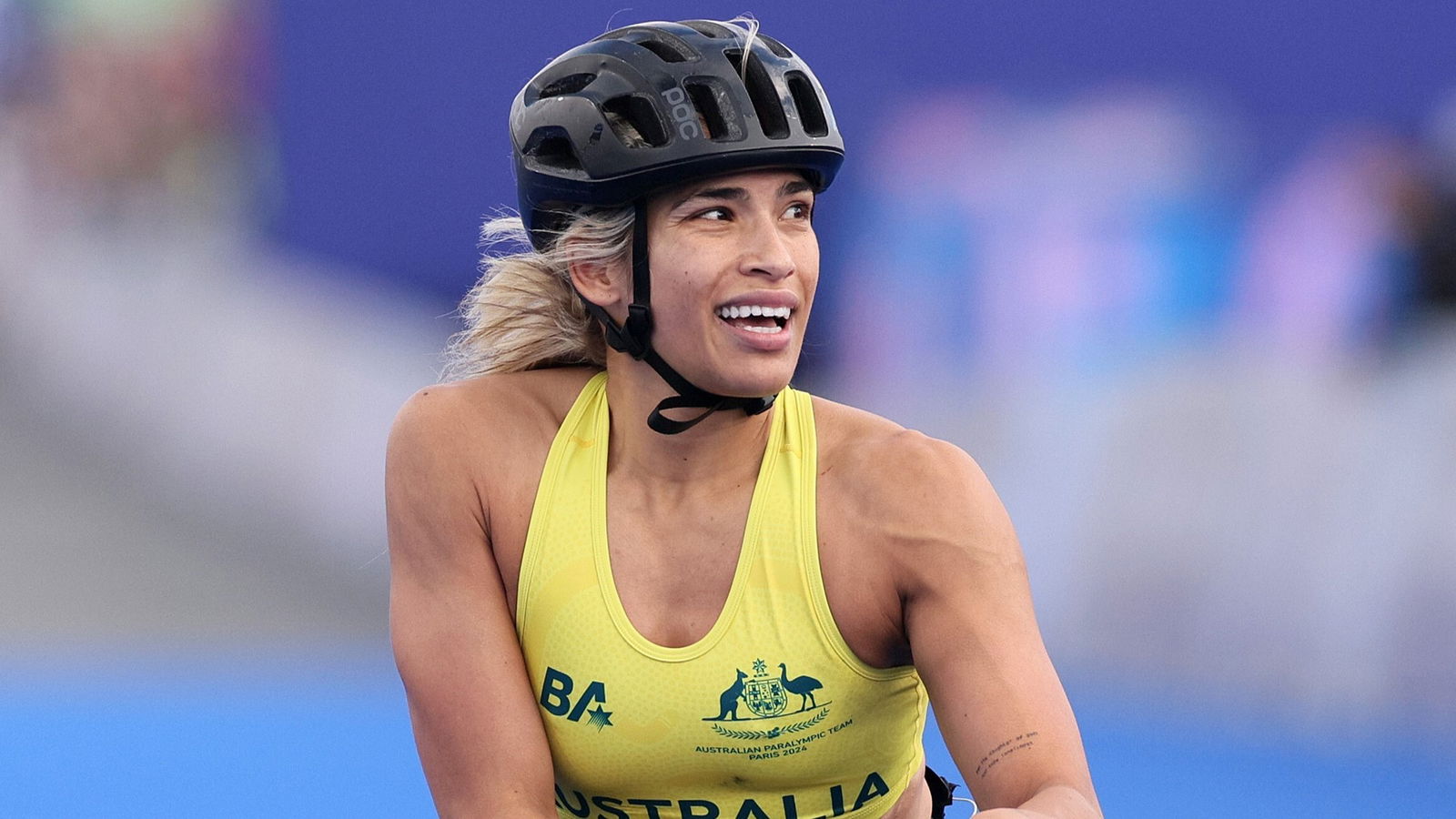 Australian wheelchair racer Madison de Rozario wears a helmet and has a big smile at the end of the marathon.