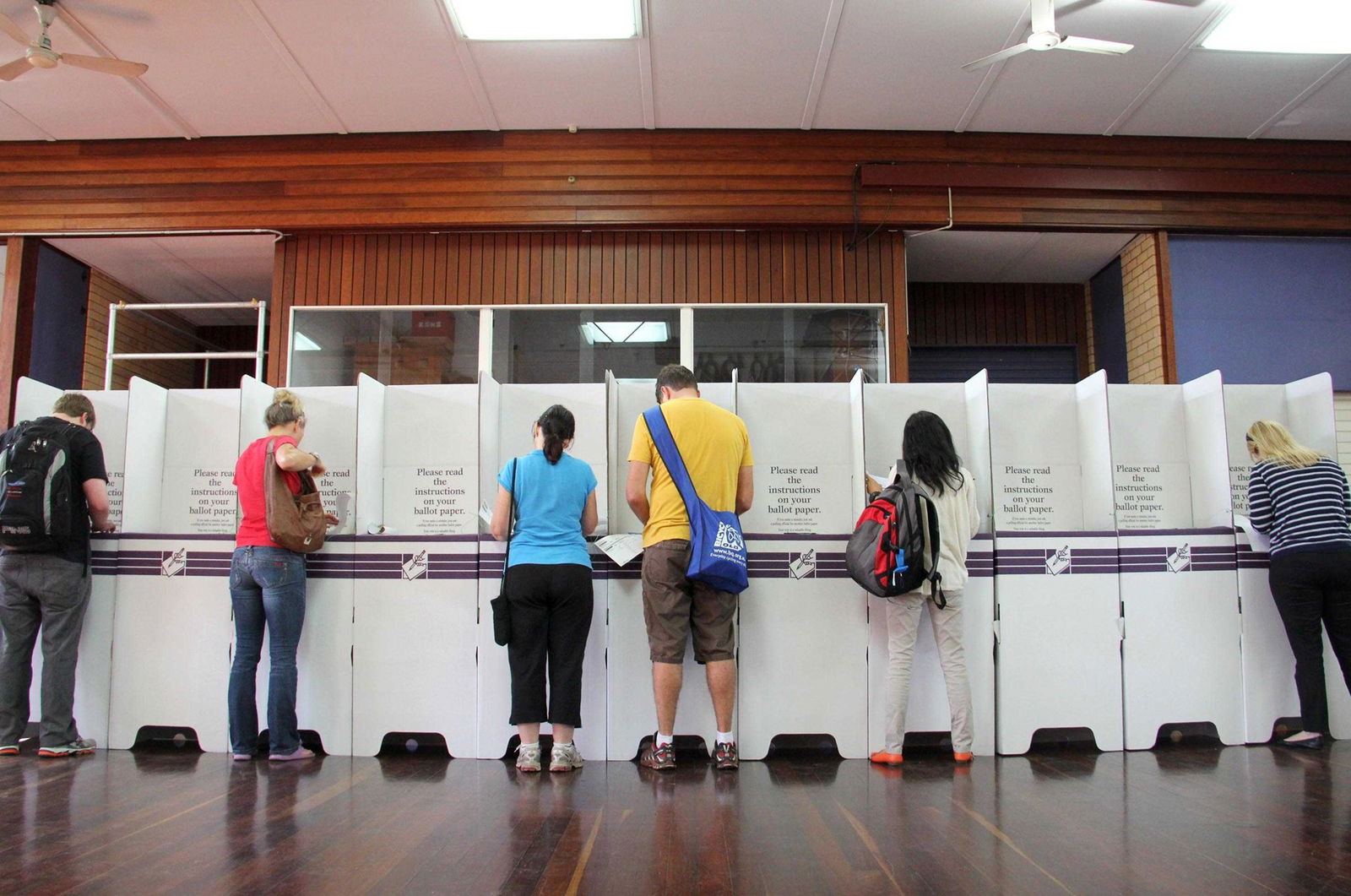 Voters at pollng booths inside a hall