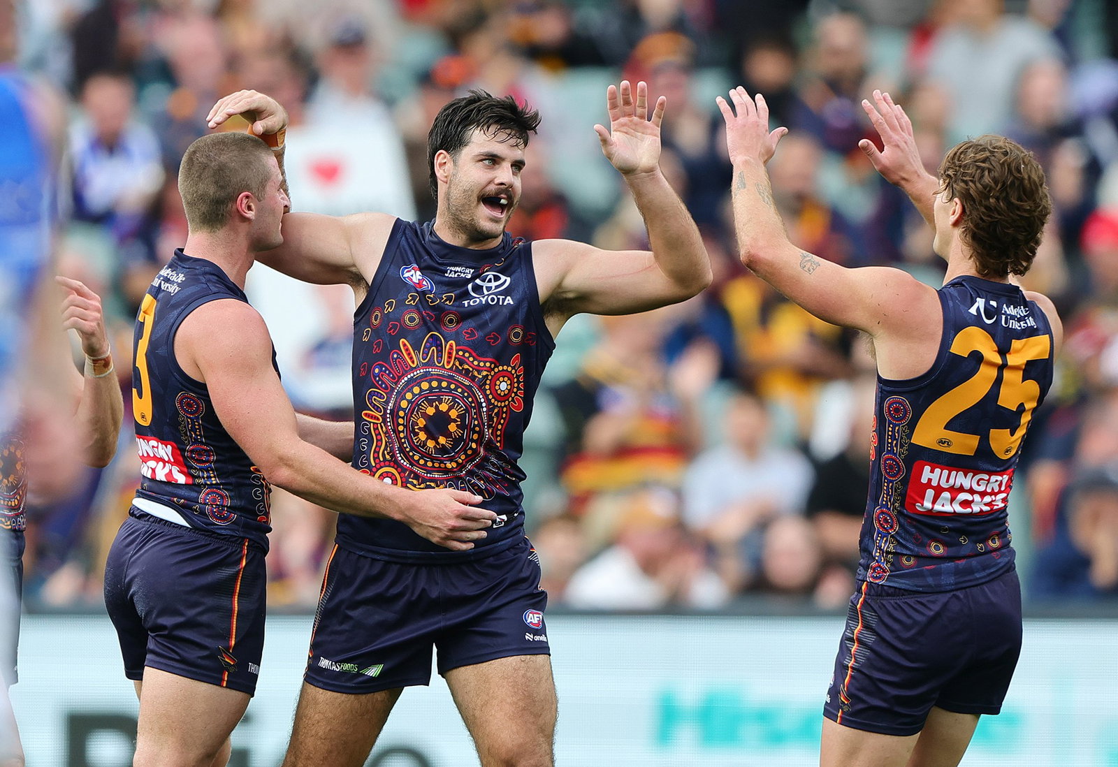 Crows players celebrate a goal.