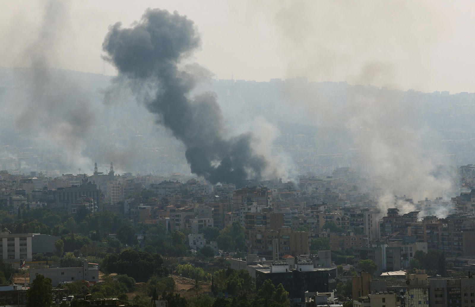 A plume of smoke over a cityscape.