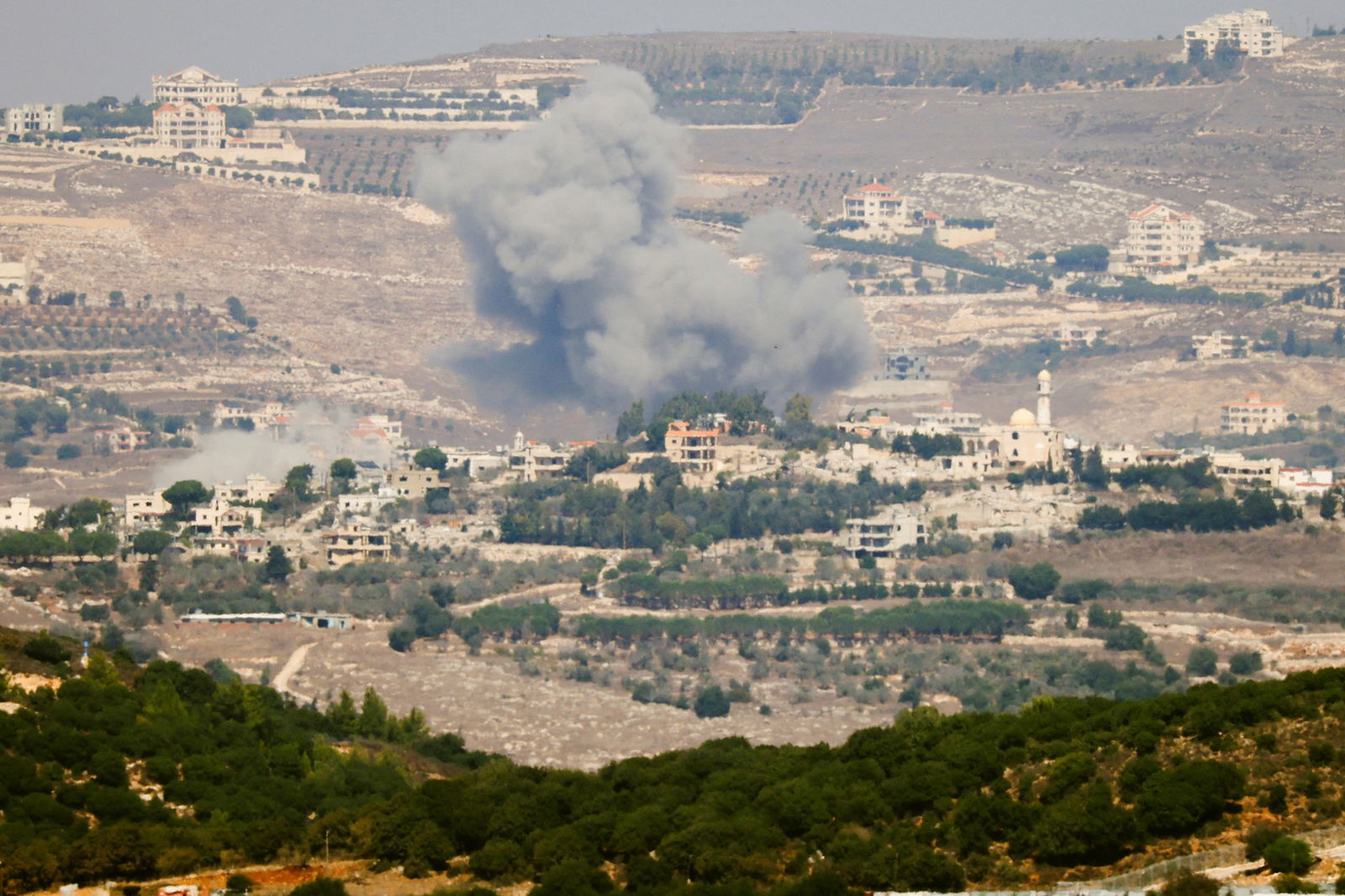 Smoke billows over a town.