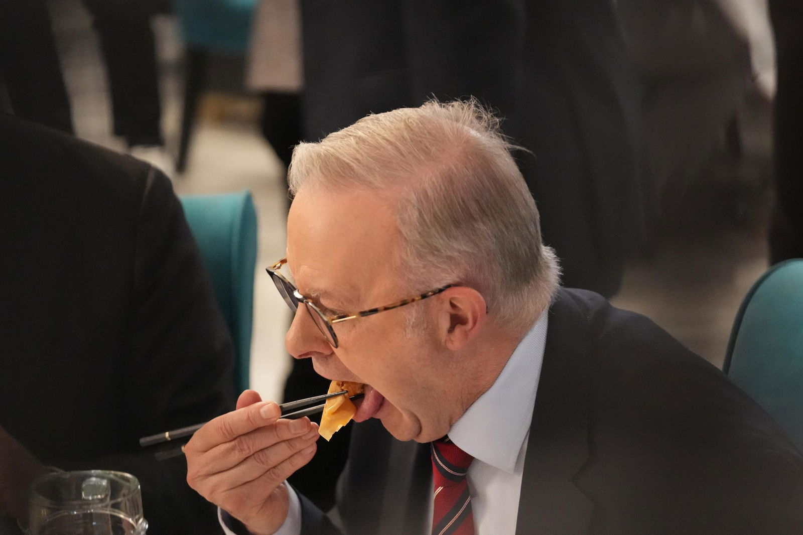 Albanese takes a bite of a spring roll 