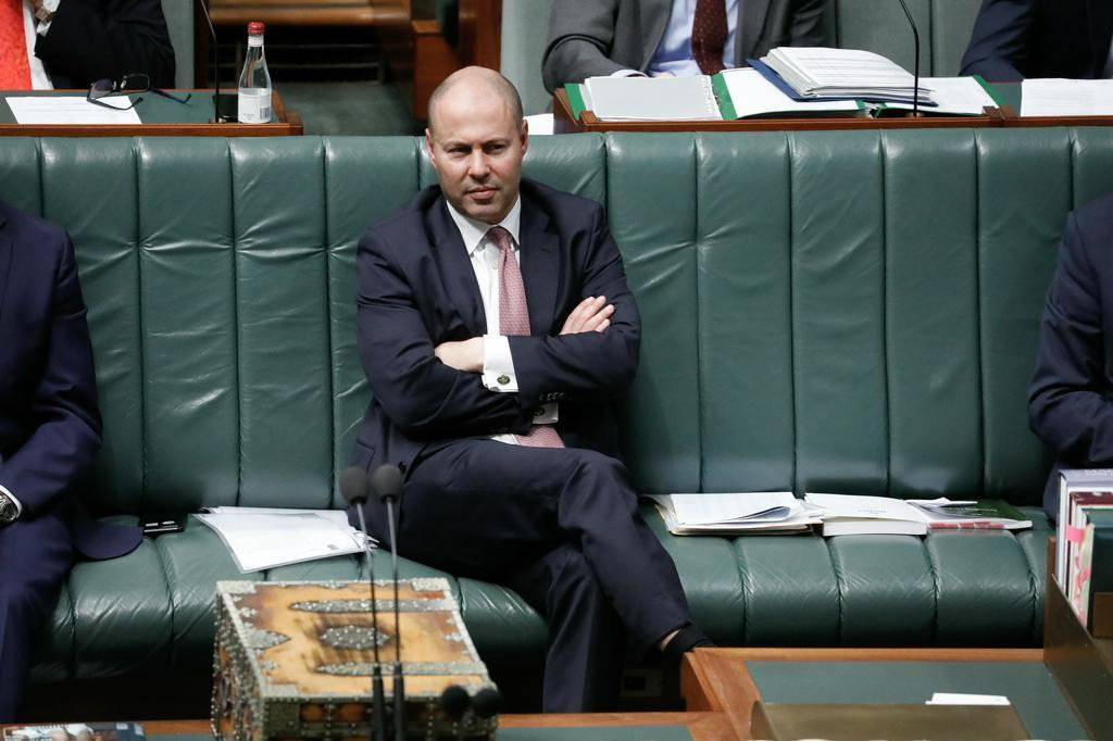 Man with his arms closed on a bench in the house of parliament.