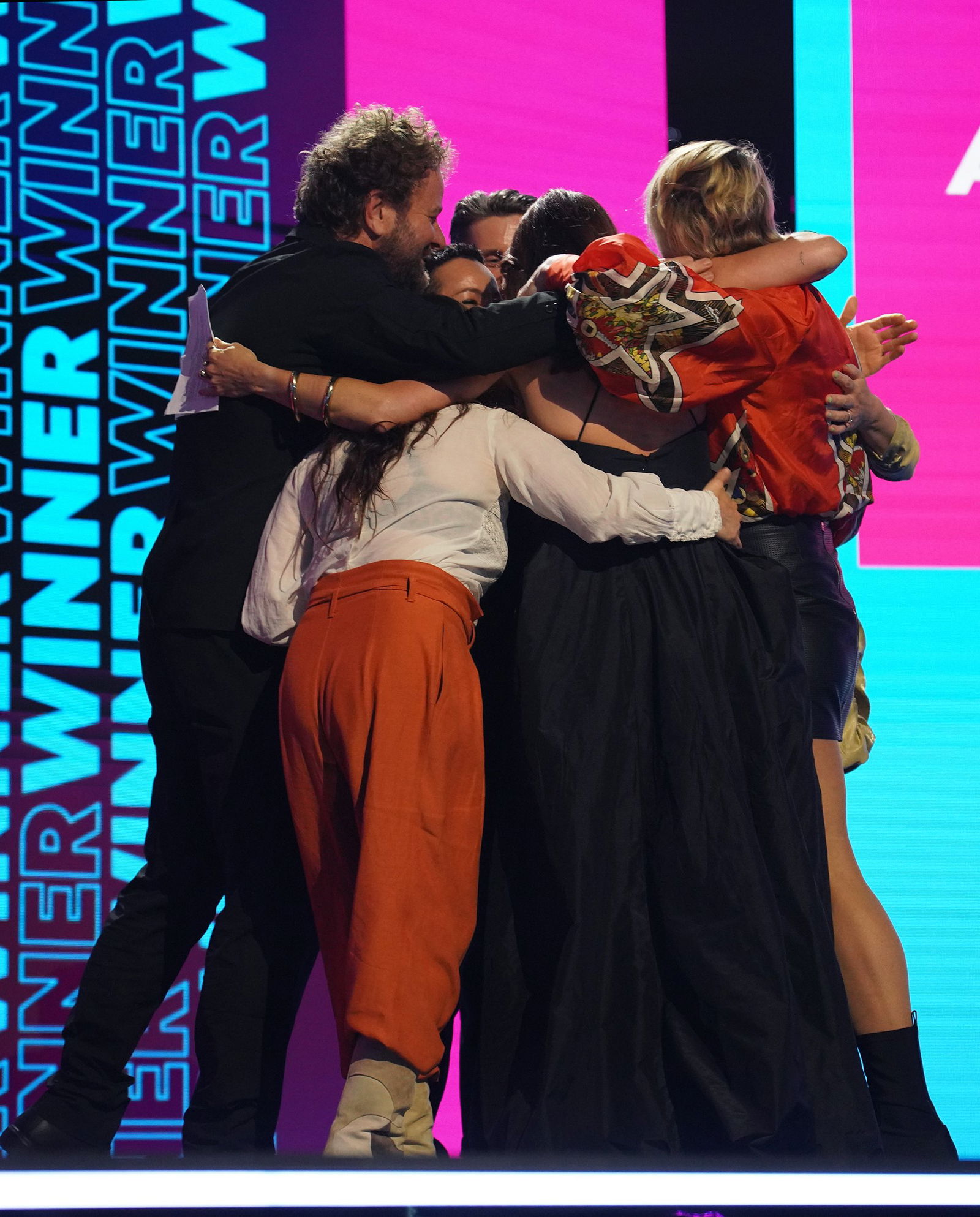 Missy Higgins's band in a group hug on stage