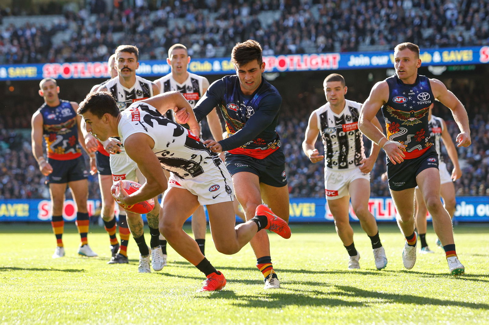 Nick Daicos of the Magpies evades Josh Rachele of the Crows during the 2024 AFL Round 10 match between The Collingwood Magpies and Kuwarna (Adelaide Crows) at The Melbourne Cricket Ground on May 18, 2024 in Melbourne, Australia.