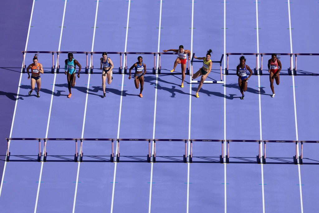 A woman hits a hurdle in the 100m