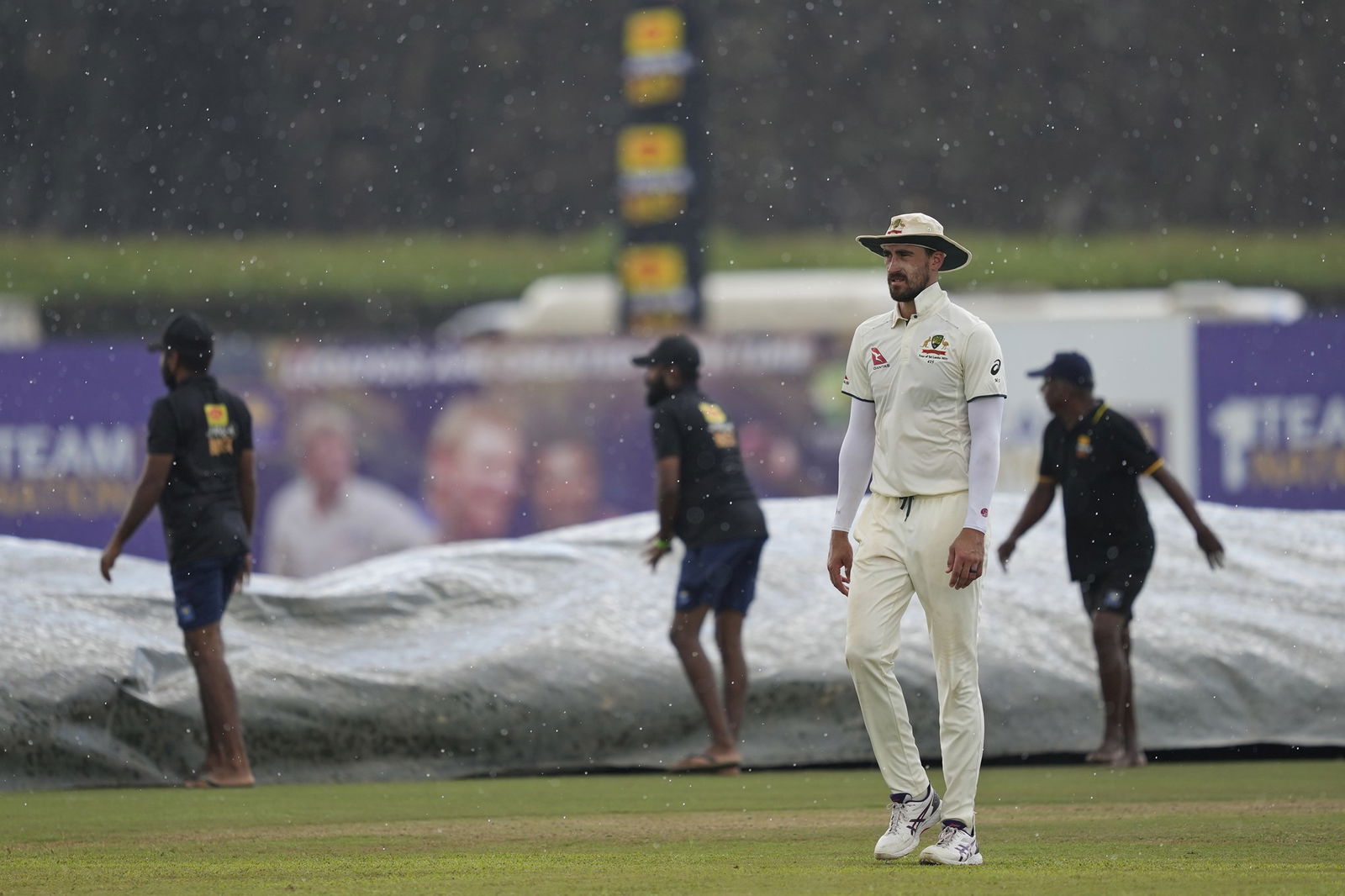 Mitchell Starc walks off the field in the rain in Galle.