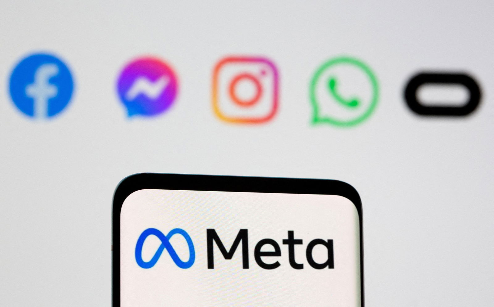 A phone with the Meta logo in front of other symbols. 